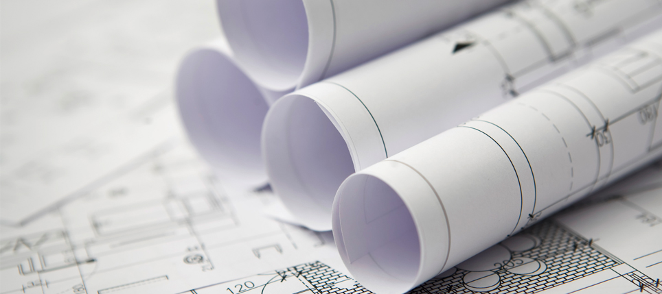 Rolled architectural drawings on a plan &mdash; new build design consultancy.