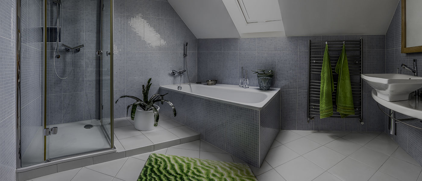 Luxury attic bathroom with grey tiled walls, bath, walk-in shower and underfloor heating &mdash; a Pat Kelleher & Sons installation.
